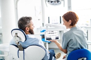 Dentist and patient smiling while reviewing X-ray