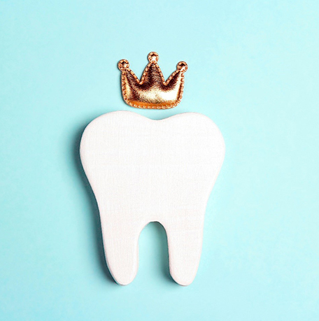a tooth with a crown against a blue background